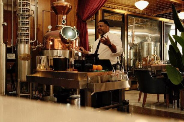 Distillery and Hospitality Education Environment Hospitality professional presenting near copper distillation equipment during a spirits education experience